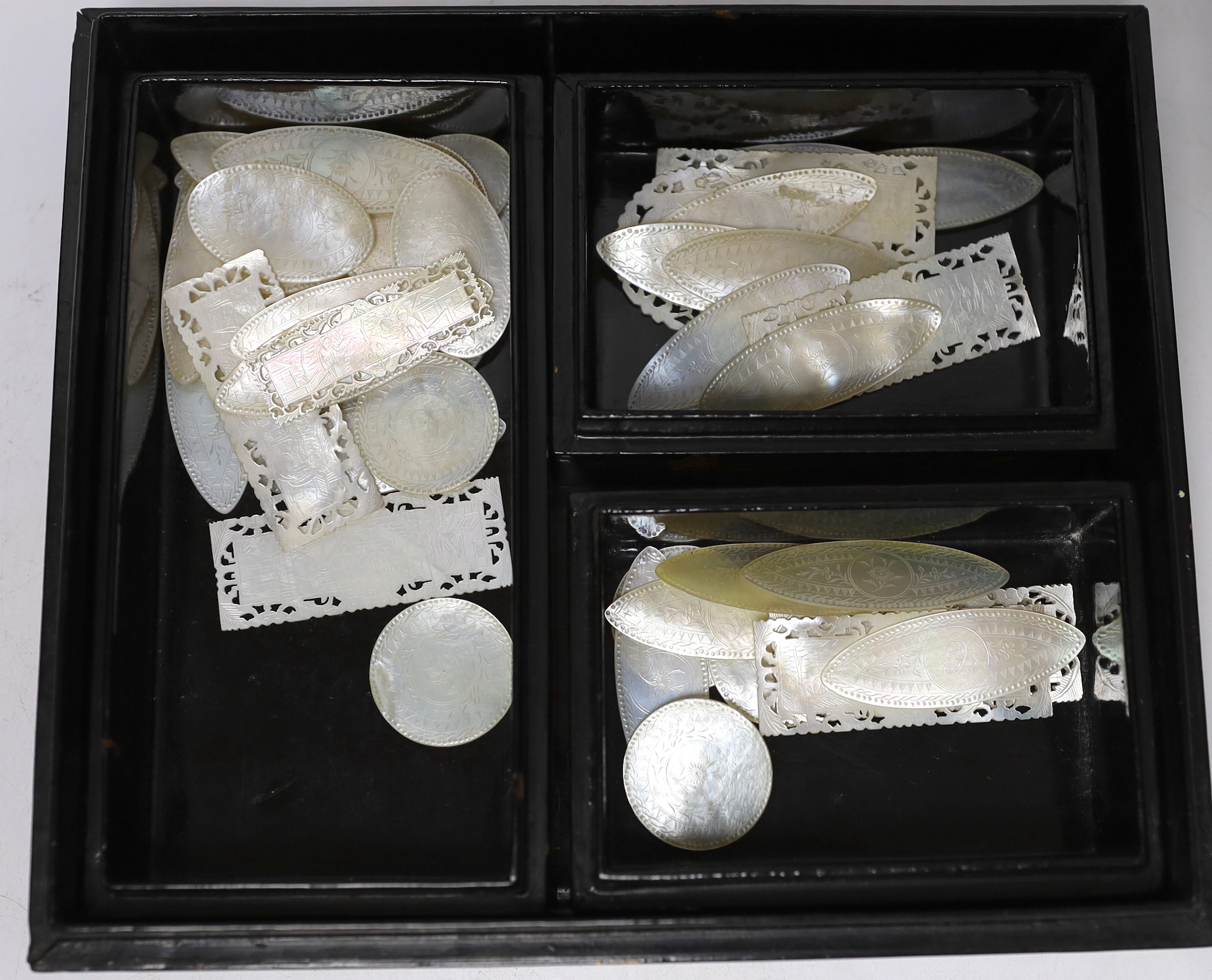 A 19th century lacquer games box with sectional interior and a collection of 49 mother of pearl gaming counters, some armorial, 22 x 19 x 5cm